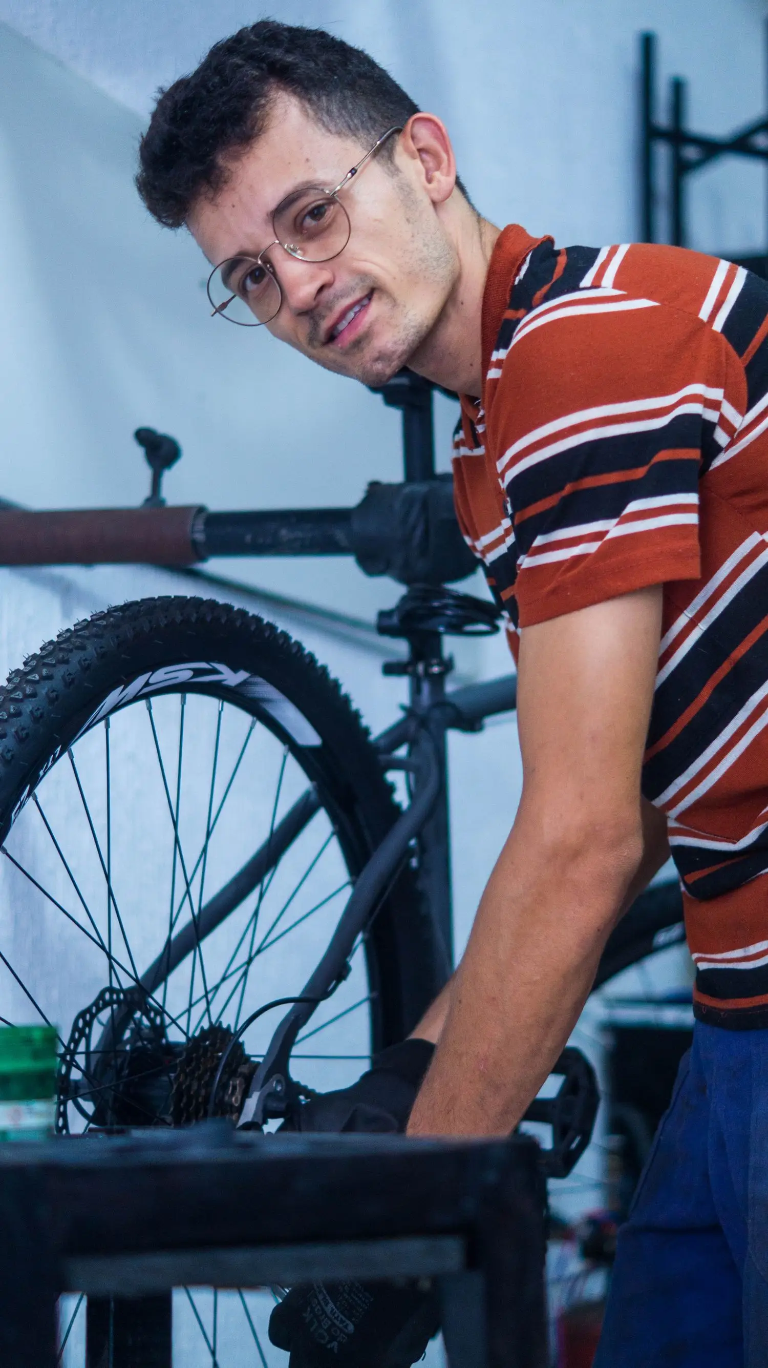 Bicycle mechanic working beside a rear wheel in the workshop